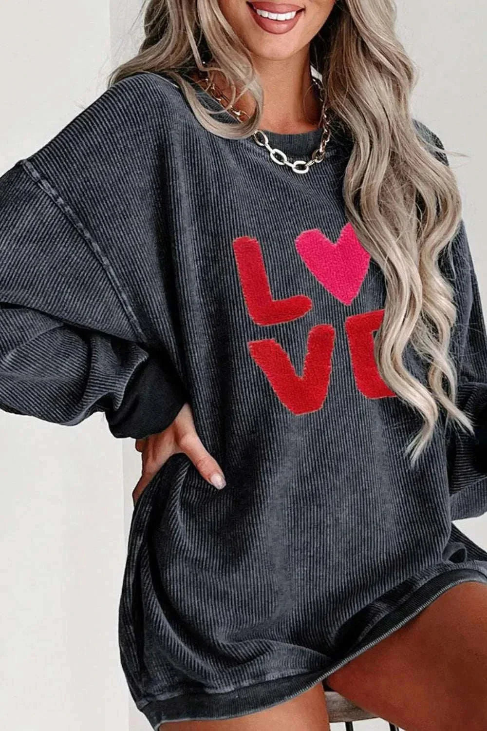 Valentine’s Day LOVE round neck long sleeve black sweatshirt with red LOVE text and heart design, slightly stretchy polyester fabric.