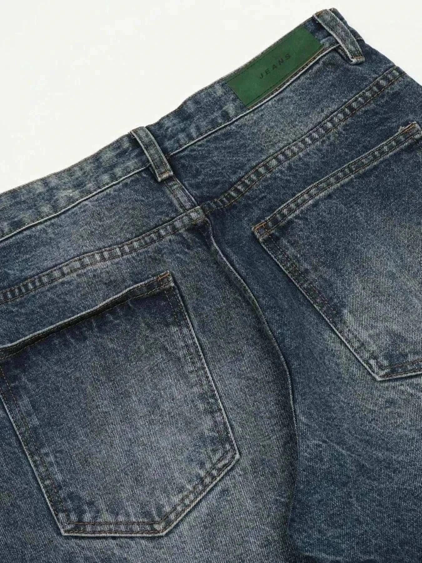 Close-up of back pockets on men's wide leg jeans in washed denim with a slight stretch blend