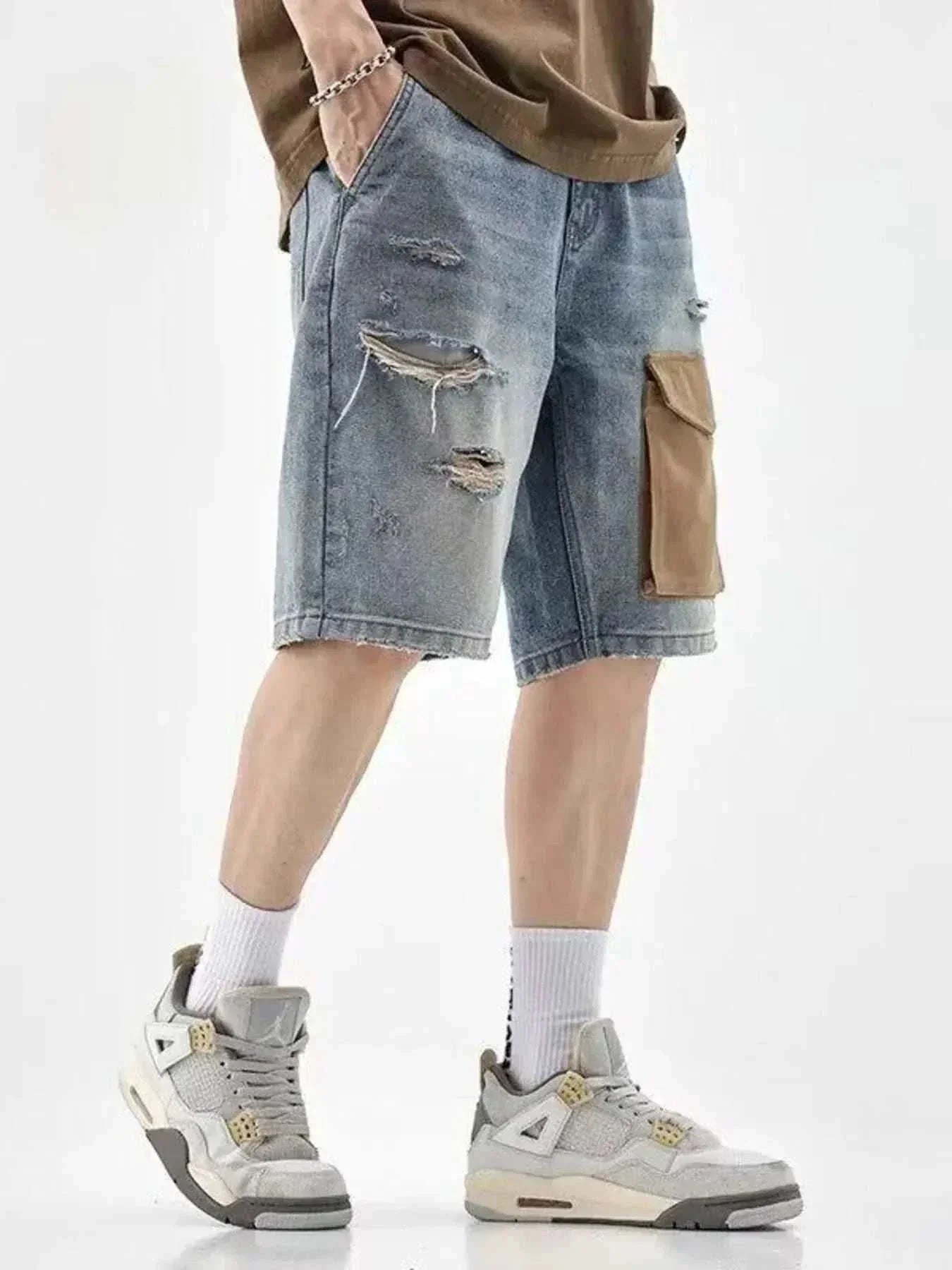 Men's distressed denim shorts with brown utility pocket and ripped details, styled with sneakers and casual top