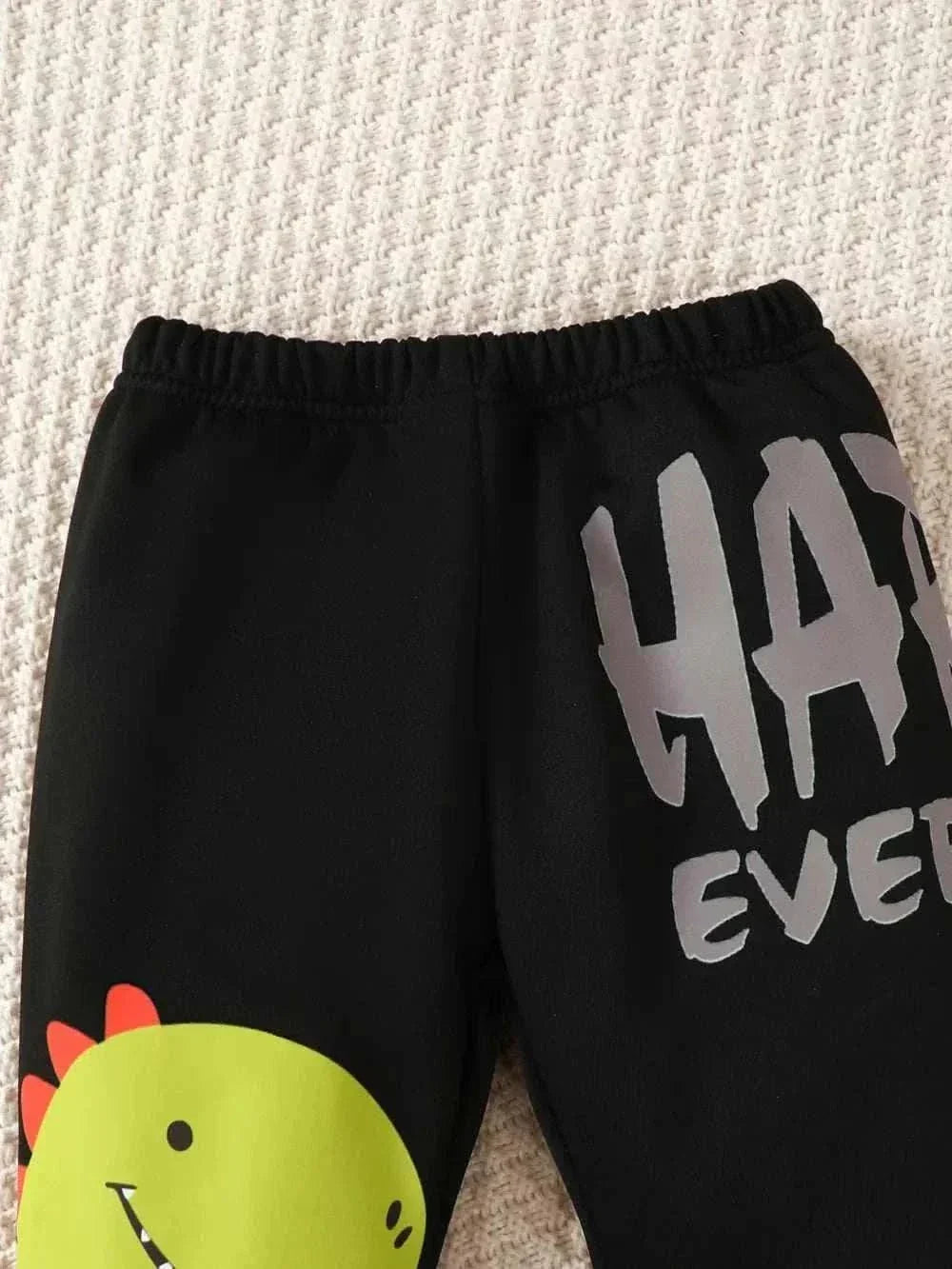 Black children's dinosaur sweatshirt set pants with green dinosaur graphic and grey text design