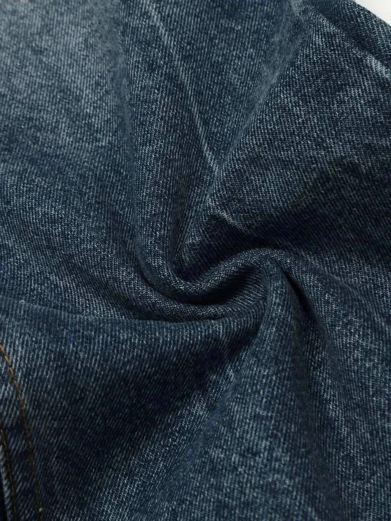 Close-up of dark blue denim fabric for men's wide leg jeans with slight texture and stretch.
