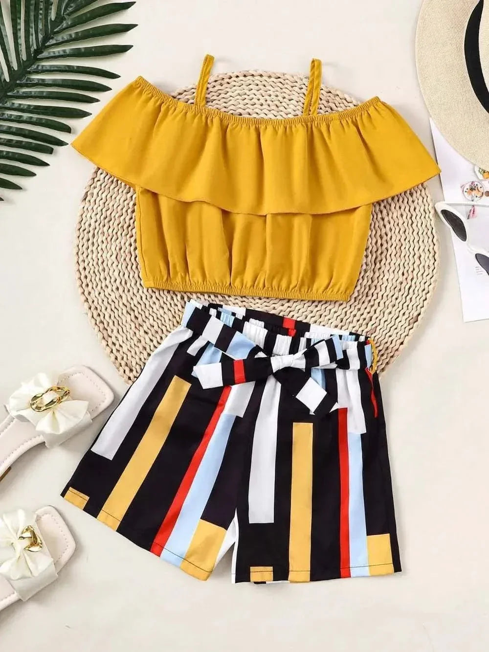 Children's ruffled mustard spaghetti strap top with multicolored striped pants set.