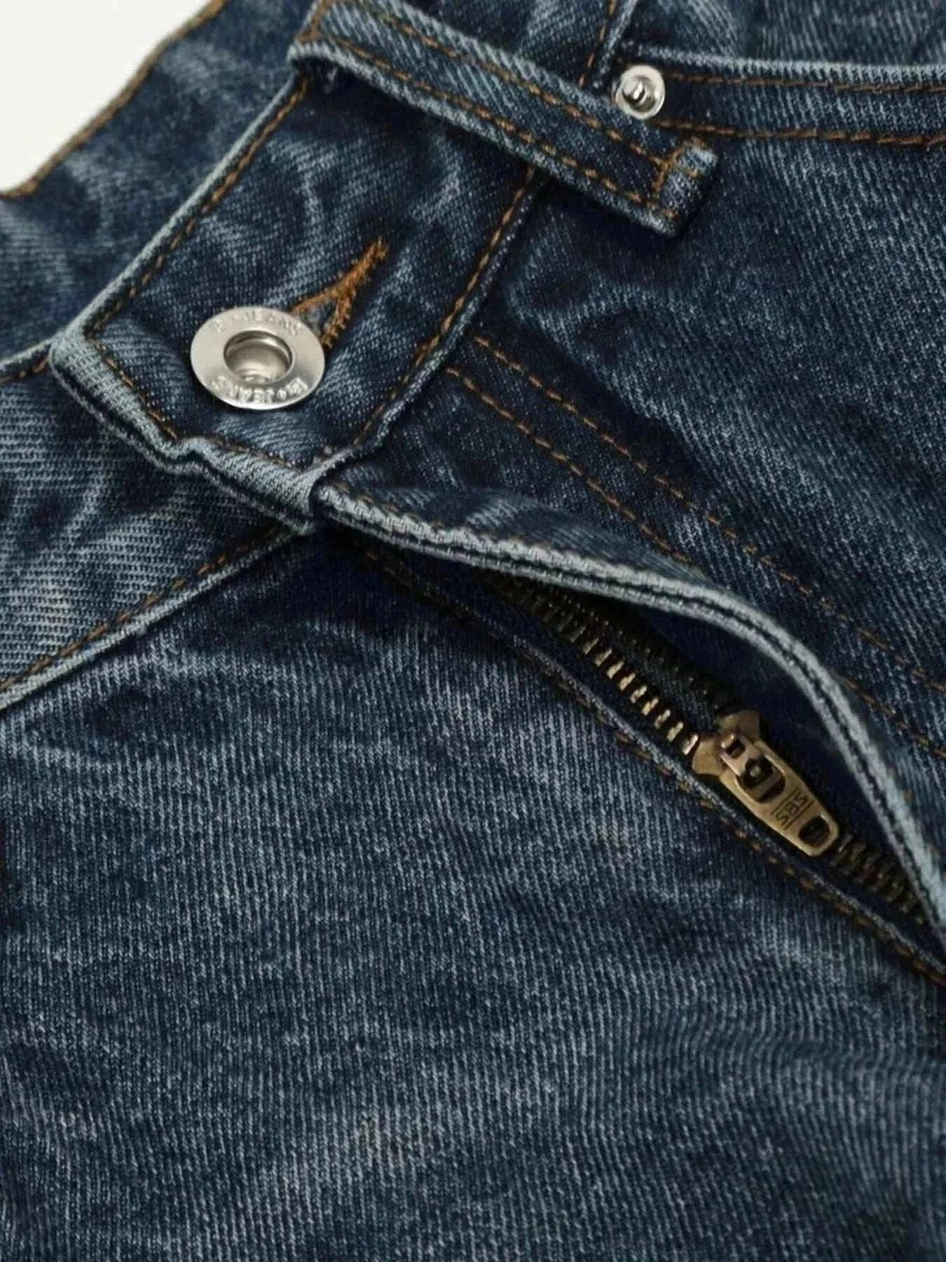 Close-up of dark washed men's wide leg jeans showing zipper and button details