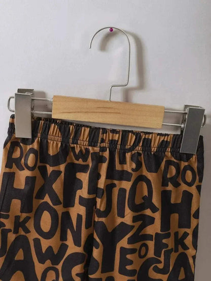 Children's Teddy Bear Round Neck Top and Pants Set featuring brown pants with black alphabet print hanging on wooden hanger.